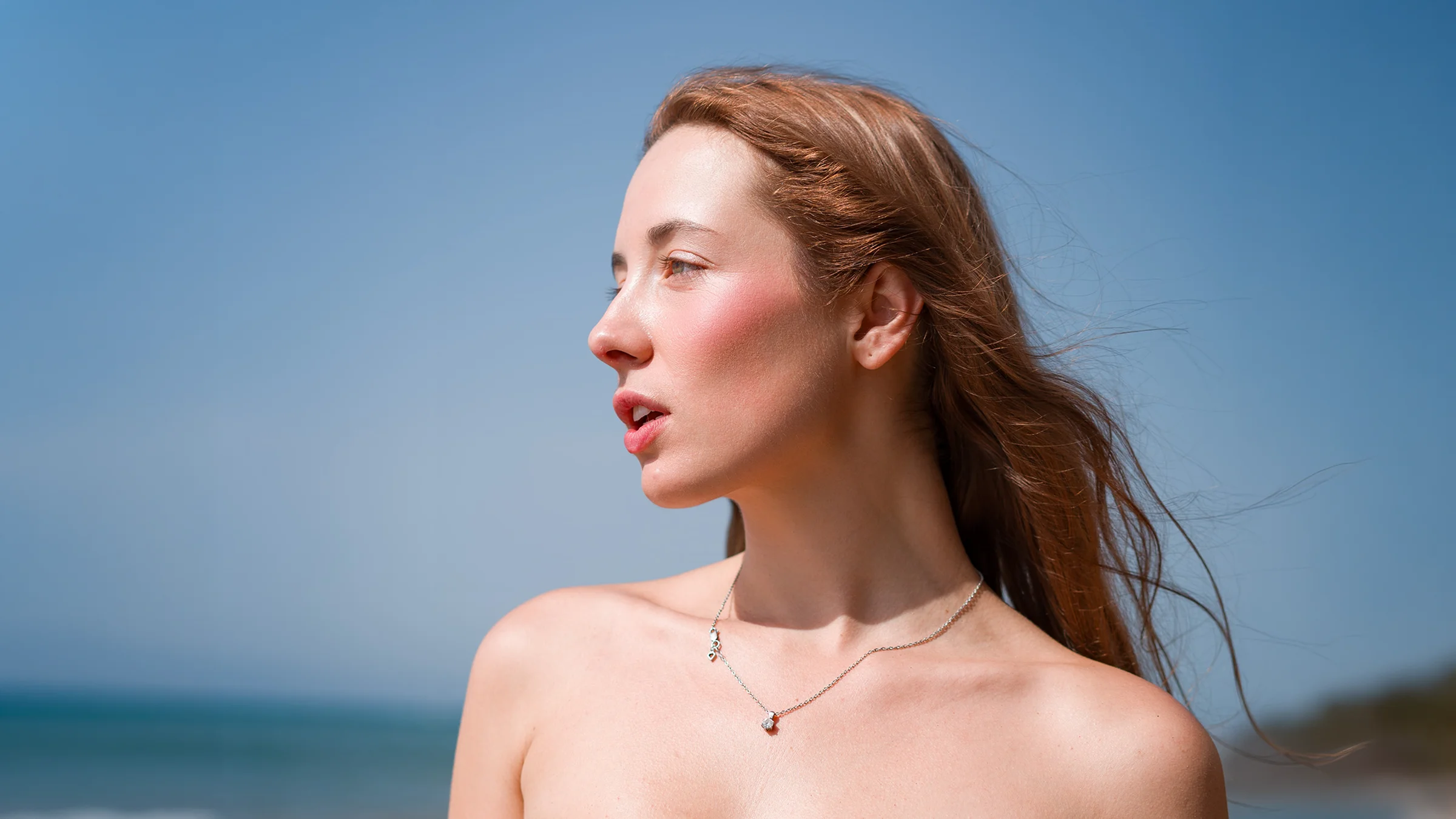 Editorial beauty portrait photograph featuring high-contrast lighting and focus on makeup details.